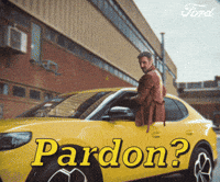 Sponsored gif. Camera rapidly zooms in on the face of a man sitting halfway out the driver’s window of a yellow vehicle. He has a curious look on his face with one eyebrow arched dramatically. Text reads, “Pardon?”