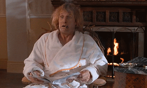 Movie gif. Wearing a white robe and chewing on a cigar, Jeff Daniels as Harry in Dumb and Dumber rises from his seat and claps enthusiastically.