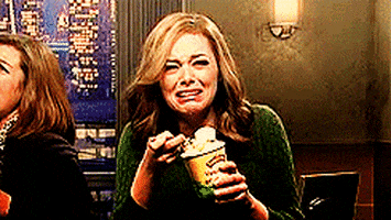 Celebrity gif. Emma Stone sobs as she crams a scoop of ice cream in her mouth.