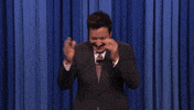 Tonight Show gif. Jimmy Fallon claps enthusiastically while looking down and laughing and he walks towards the camera as he claps. He blows a two handed kiss at us.