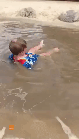 Happy Child Lives His Best Life by Splashing Around in Muddy Puddle