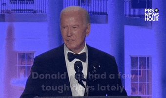 Video gif. President Joe Biden stands behind a podium at the 2024 White House Correspondents' Dinner as he delivers a joke. He says "Donald has had a few tough days lately. You might call it..." and pauses before saying "stormy weather."