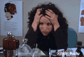 Seinfeld gif. Julia Louis-Dreyfus as Elaine sitting with her elbows on the desk, head in her hands, looking stressed.