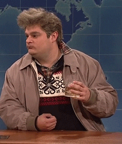 SNL gif. Bobby Moynihan as Drunk Uncle sits at the Weekend Update desk with a drink in his hand. He looks around disoriented like he’s had too much to drink and now the alcohol has made him paranoid. He slowly scoots himself in his chair away from the desk to get himself out of the situation.
