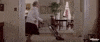 Movie gif. Robin Williams as Mrs Doubtfire dances while vacuuming a room.