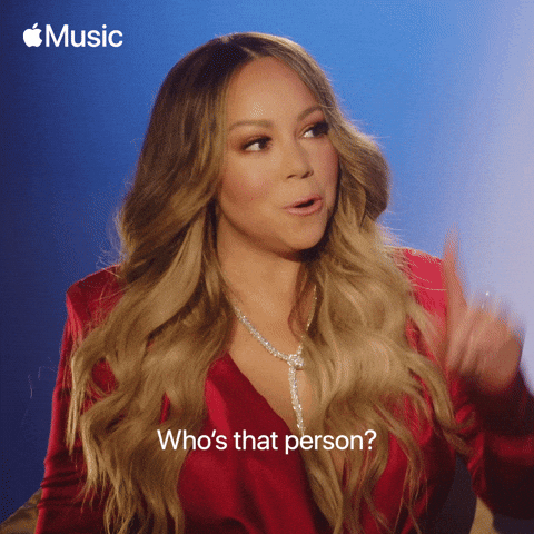 Celebrity gif. Mariah Carey pointing up to the right and saying, 