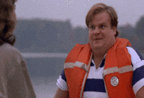 Movie gif. Chris Farley as Tommy in Tommy Boy wears an orange life vest and sits across from a woman. He shakes his head out of disbelief and chuckles as he says, “That was awesome!”