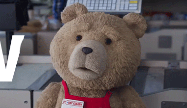 Movie gif. Ted the CGI teddy bear from Ted in his red work apron raises his eyebrows and says "Wow!"