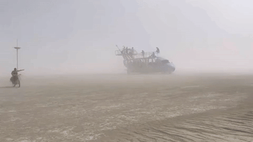 Burning Man Attendees Bike in Black Rock Desert Dust Storm