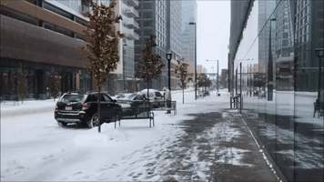 Cars Navigate Snowy Roads in Downtown Denver