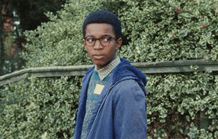 TV gif. Kenyah Sandy as Kingsley Smith in Small Axe: Education, angrily turns past his shoulder to wholeheartedly give two fingers.