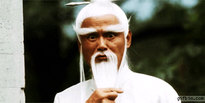 Movie gif. Gordon Liu as Pai Mei in Kill Bill. He strokes his long white beard slowly and intimidatingly as he stares us down. He tosses his beard over his shoulder and assumes a fight stance.