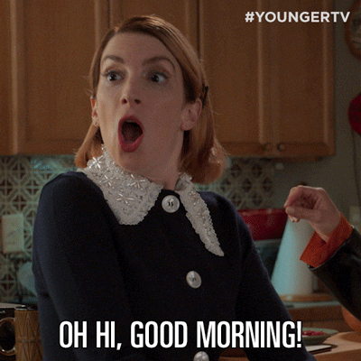 TV gif. Molly Kate Bernard as Lauren on Younger. She has her mouth open in shock and she attempts to cover up her shocked awkwardness by eagerly saying, "Oh, hi! Good morning!"