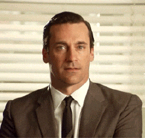TV gif. Jon Hamm as Don in Mad Men grins as he gives a wink. 