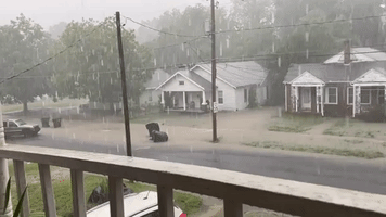Floodwaters Sweep Trash Bins Down Street in Central North Carolina Amid Heavy Rainfall