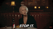 Celebrity gif. Helen Mirren sits in a restaurant booth with a burger and fries plated in front of her with a bottle of beer as her beverage. She looks over at someone with an irritated expression and says, “Stop it.”
