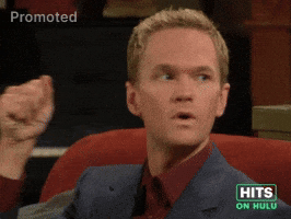 Sponsored GIF. Neil Patrick Harris holds his right fist up next to his face as if he has a surprise. He fans his fingers open to reveal, “You’re a jerk!” Is written on his palm.