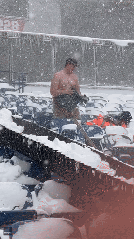 Shirtless Snow Shoveler Slides Down Chute at Buffalo Bill's Stadium During Blizzard Conditions