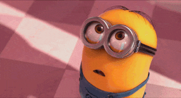 Cartoon gif. Minion looks up with a gaping mouth that turns into a blissful smile.