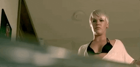 Celebrity gif. P!nk blinks and tilts her head in confusion at an object partially obscuring the camera, which she looks down at