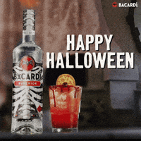 Sponsored gif. A Halloween-themed bottle of Bacardi and an orange cocktail on a countertop. Behind them, a curtain blows mysteriously and an old fashioned TV set shows spooky static. Text reads "HAPPY HALLOWEEN"