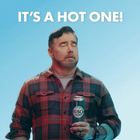 Sponsored gif. Gerald Downey in a red and black plaid shirt slowly wipes his brow with a can of cold Busch Light beer like he's really enjoying the moment. He smiles with relief and gives a quick cheers. Text, "It's a hot one!"