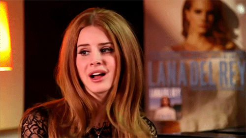 Celebrity gif. Lana Del Rey tilts her head with a look of disproval.