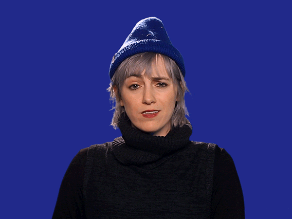 Video gif. Against a blue background, a woman with short blonde hair wearing a blue beanie rolls her eyes and scoffs before looking at us pointedly.