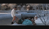 Movie gif. Randy Quaid as Cousin Eddie in National Lampoon's Christmas Vacation stands in a bathrobe as he holds a thick hose into a storm drain on a street. He raises a beer in the other hand as if saying hello. 