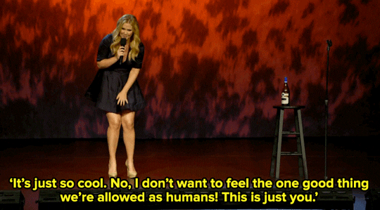 Celebrity gif. Performing standup, Amy Schumer pats her thighs with her palm and then gestures at the audience with her hand while she says "It's just so cool. No, I don't want to feel the one good thing we're allowed as humans! This is just you," which appears as text.