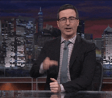 TV gif. John Oliver on Last Week Tonight holds an imaginary cup and toasts us, saying, "Cheers," while pretending to sip the cup.
