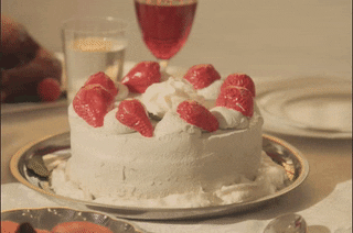 Video gif. The words "happy anniversary" appear over a white-frosted cake decorated with strawberries, which suddenly gets stepped on by a person wearing clear pleaser heels.