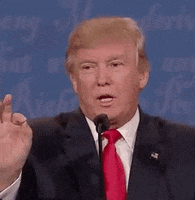 Politics gif. Donald Trump behind a mic, raises his index finger and opens his mouth, about to speak, then drops his hand and closes his mouth.