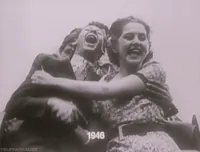 Video gif. Black and white footage captures people laughing and holding on to each other as they ride on a roller coaster. Text, 