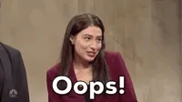 SNL gif. Actor Melissa Villasenor impersonating Alexandria Ocasio Cortez shrugs and puts her hands to her mouth with a mischievous smile. The text says, 
