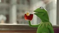 Video gif. Kermit the Frog, sitting in front of a brightly lit window, happily sips a cup of hot Lipton out of a clear mug. He takes a sip, then mouths, 
