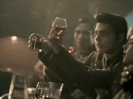 Music video gif. Men dressed as World War Two soldiers toast each other haphazardly at a bar in the video for My Chemical Romance's The Ghost of You.