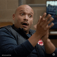 TV gif. Joe Minoso as Joe from Chicago Fire raises his eyebrows and nods, giving a smug frown as he claps his hands slowly.