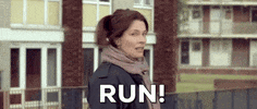 Movie gif. Woman from the 2019 movie, Zoo, turns around in fear and yells, "run!"