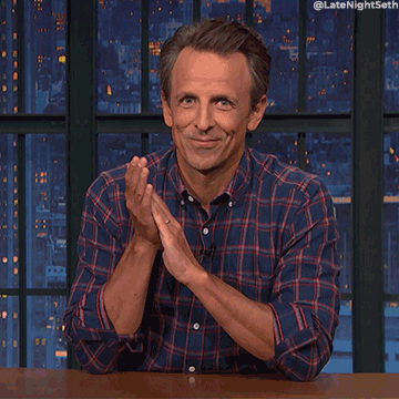 Late Night gif. Seth Meyers looks at us, smiling and clapping.