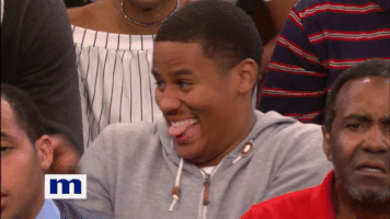 Reality TV gif. A man on the Maury show in the audience wearing a gray hoodie rocks back and forth excitedly, and smiles with his tongue sticking out from between his teeth.