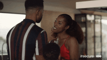 TV gif. Issa Rae on Insecure leans in to greet Jay Ellis as Lawrence and they kiss on the lips.