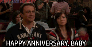 TV gif. Jason Segel and Alyson Hannigan as Marshall and Lily in How I Met Your Mother sitting together in their booth smirk as they high five in perfect unison. Text, "Happy Anniversary, Baby."