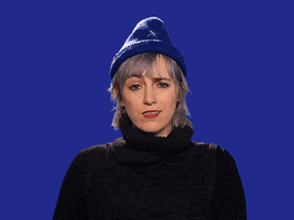 Video gif. Against a blue background, a woman with short blonde hair wearing a blue beanie rolls her eyes and scoffs before looking at us pointedly.