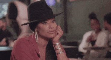 Reality TV gif. Tami Roman from Basketball Wives sits with her chin perched on her hand, shaking her head and pursing her lips in disapproval.