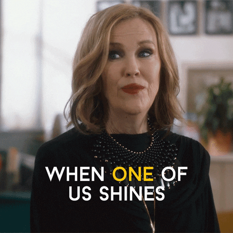Gif of Moira from Schitt's Creek saying "when one of us shines, all of us shine"