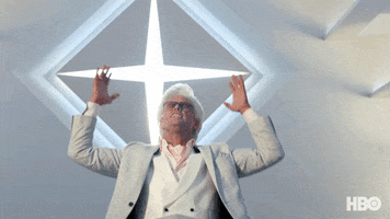 TV gif. Walton Goggins as Baby Billy Freeman from The Righteous Gemstones seems to be having a spiritual moment. Wearing white clothes in a white room, he raises his hands emphatically beneath a four-pointed star decoration.